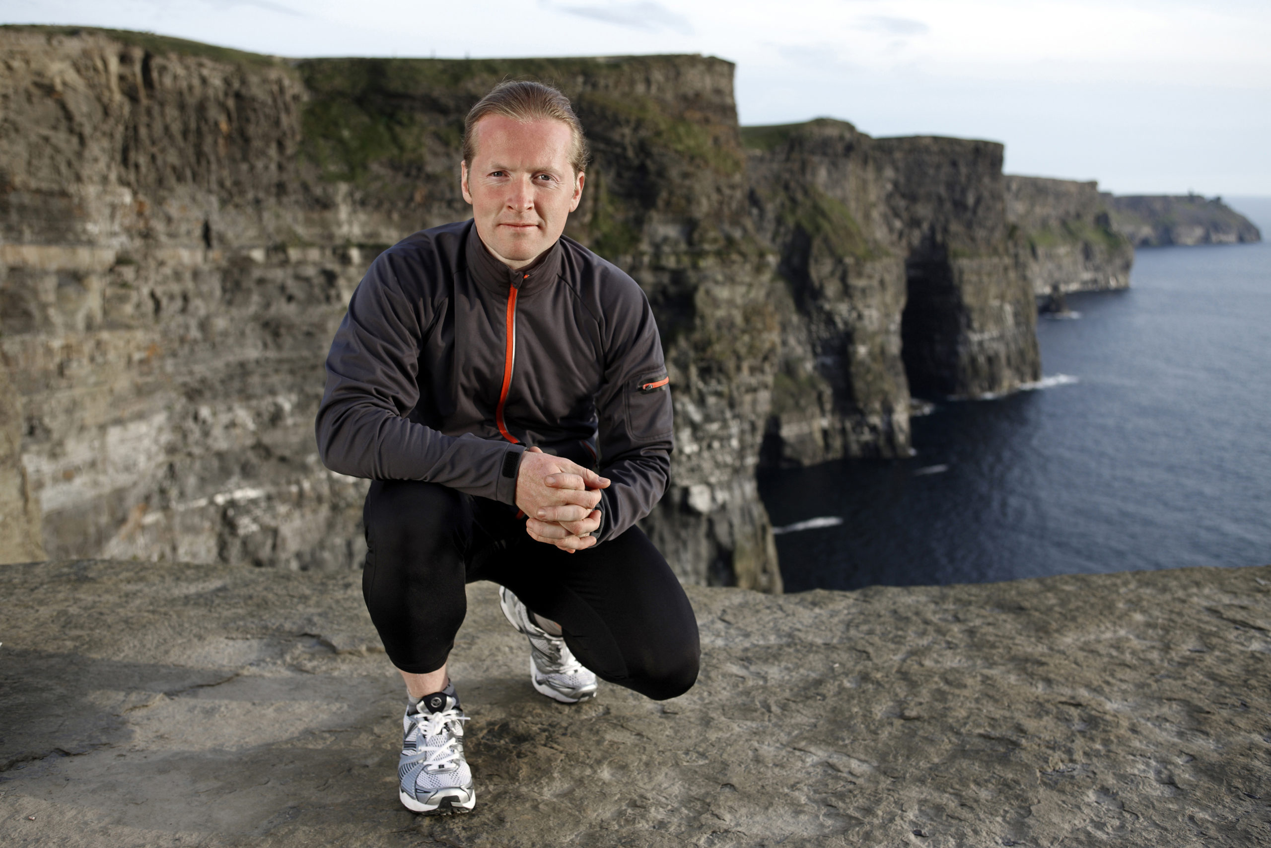 Joey Kelly on a rock by the sea endurance sport