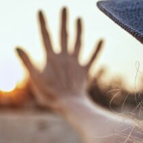 Woman with a hat touching the window