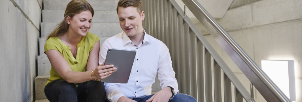 Team members collaborating at a laptop in a modern office, illustrating how a platform company enables efficient digital workflows.