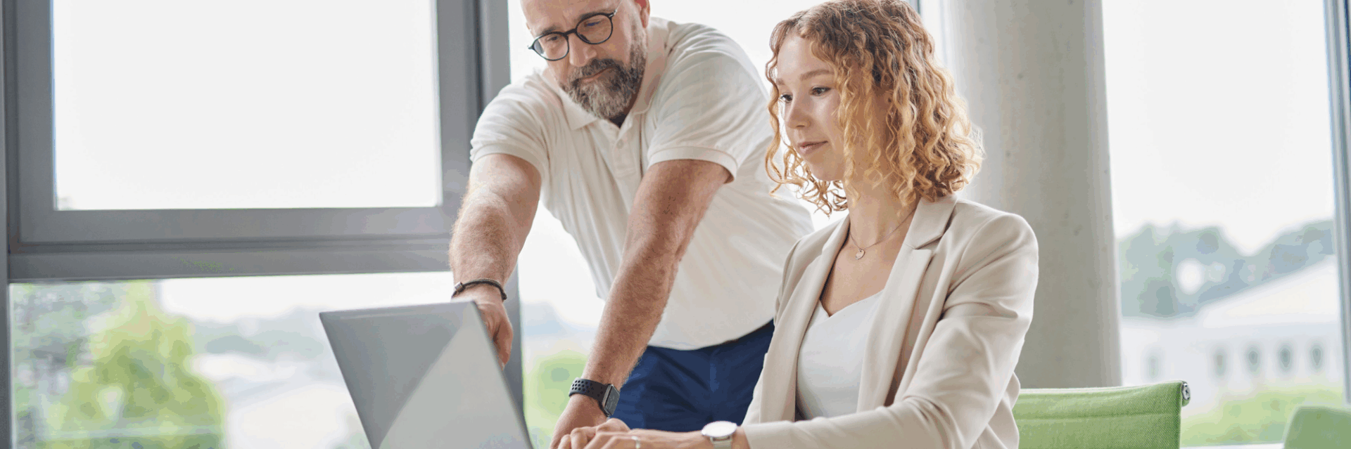 Team members collaborating at a laptop in a modern office, illustrating how a platform company enables efficient digital workflows.