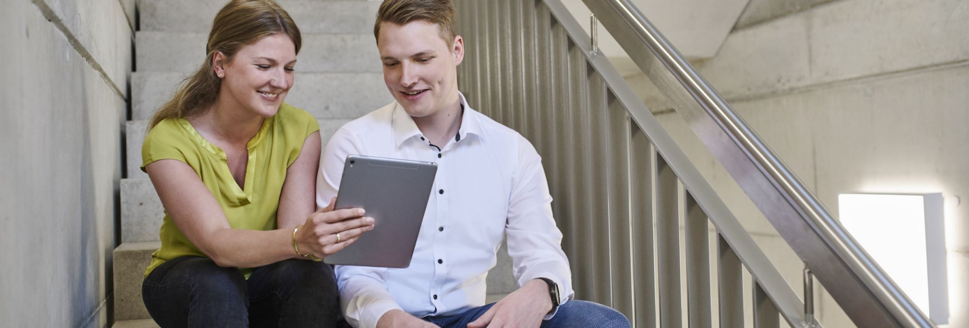 Team members collaborating at a laptop in a modern office, illustrating how a platform company enables efficient digital workflows.