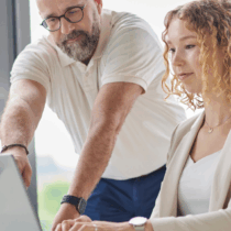 Team members collaborating at a laptop in a modern office, illustrating how a platform company enables efficient digital workflows.