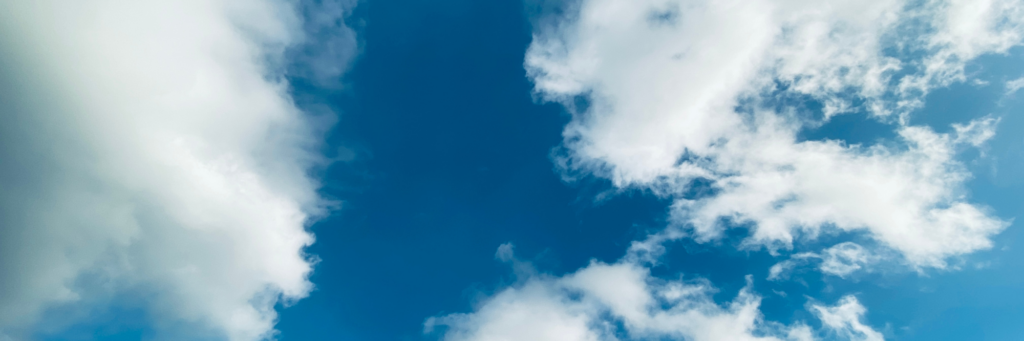 Blue sky with white clouds used as a header banner for an article about cloud first and hybrid cloud strategies.
