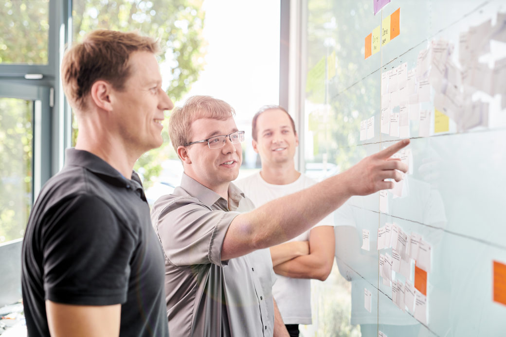 people explaining the procure to pay process on a whiteboard