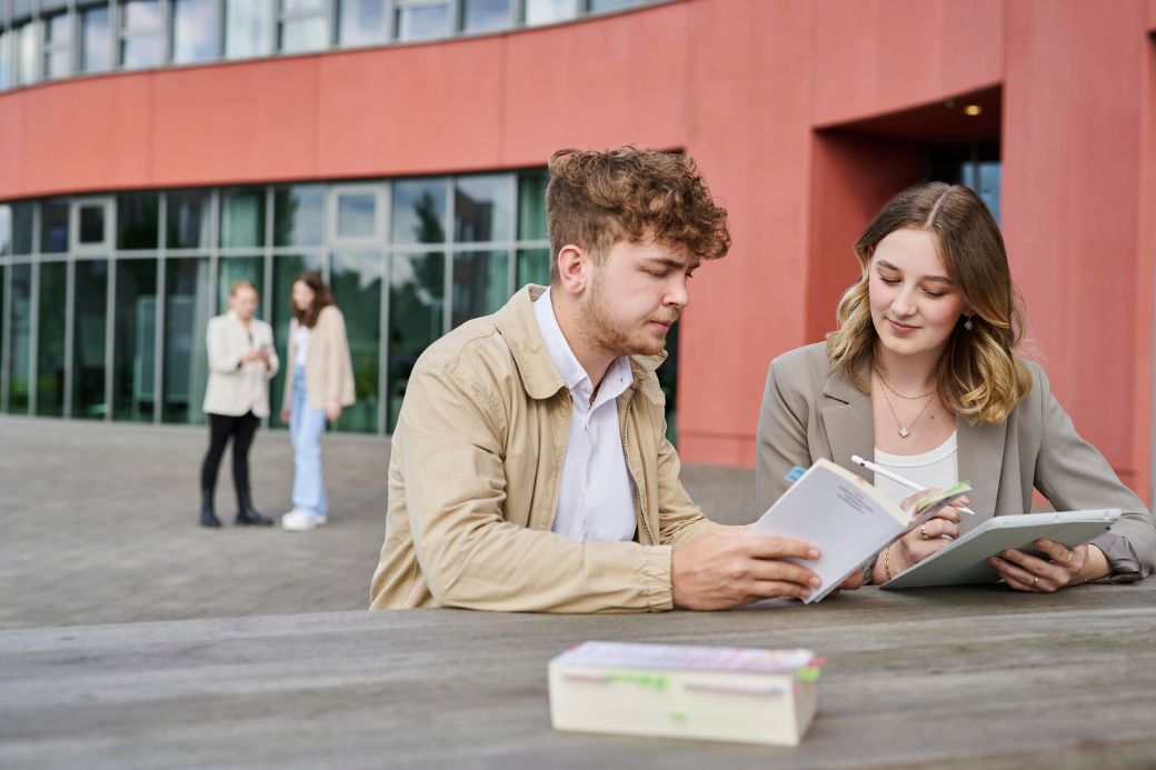 Two people sitting outside studying