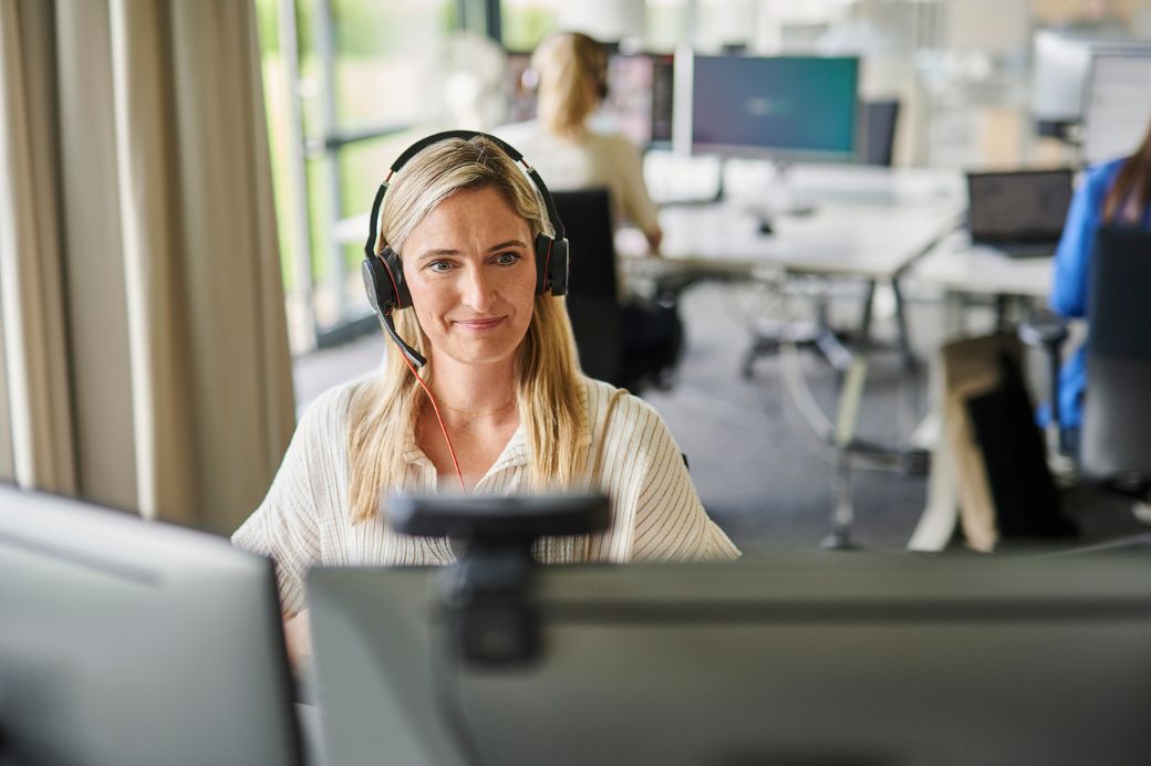d.velop employee is watching a webinar on the laptop by headphones