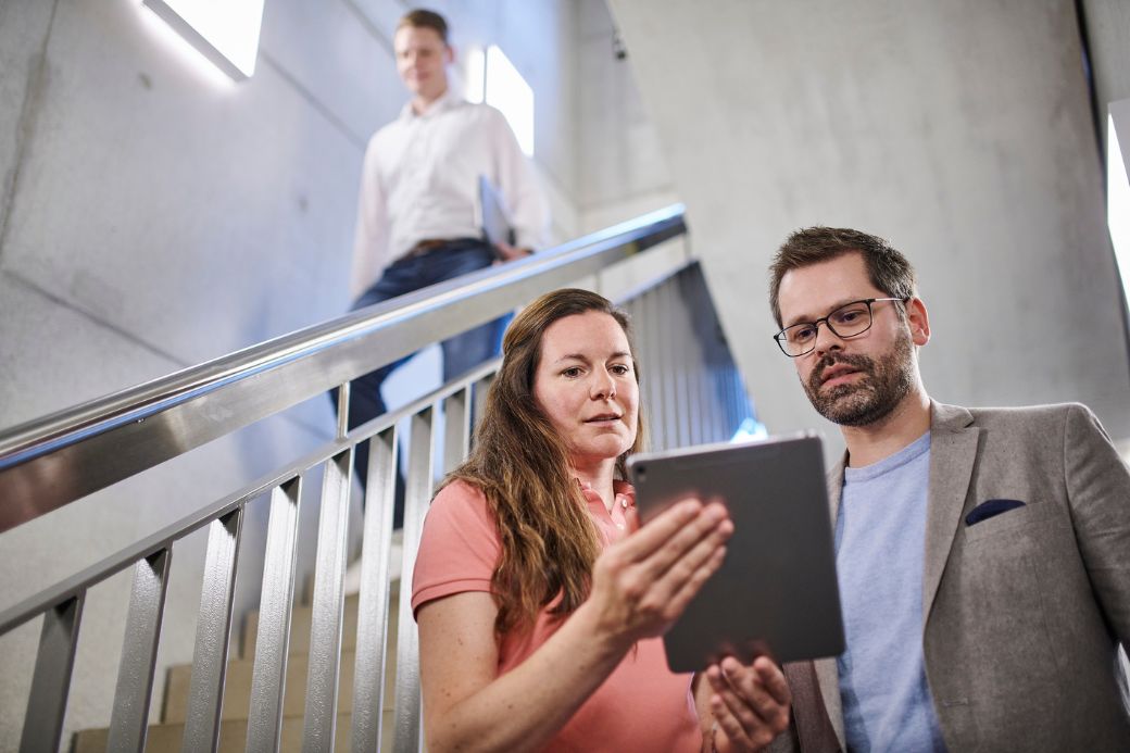employee in staircase looking at tablet