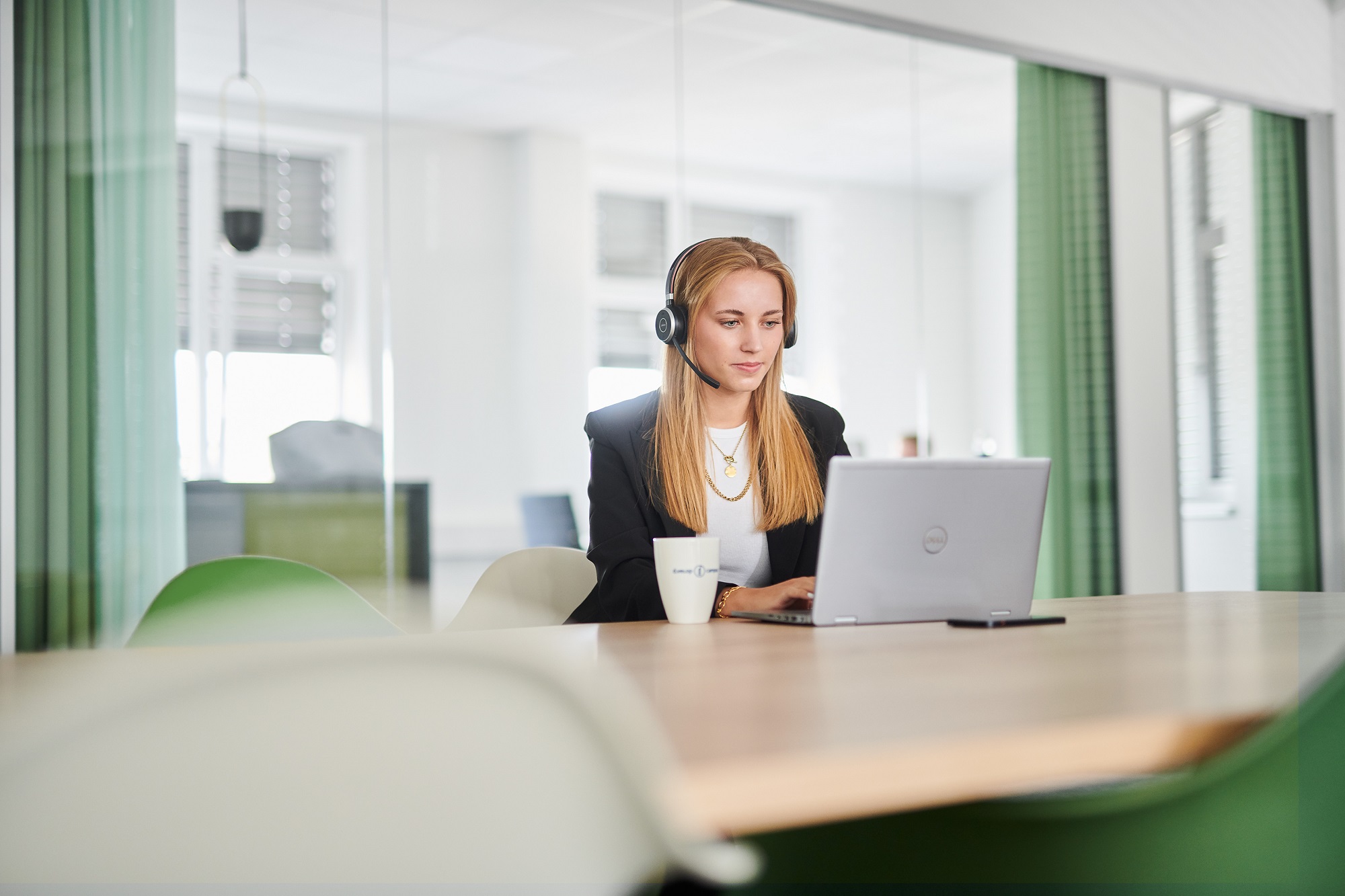 d.velop employee is watching a webinar on the laptop by headphones