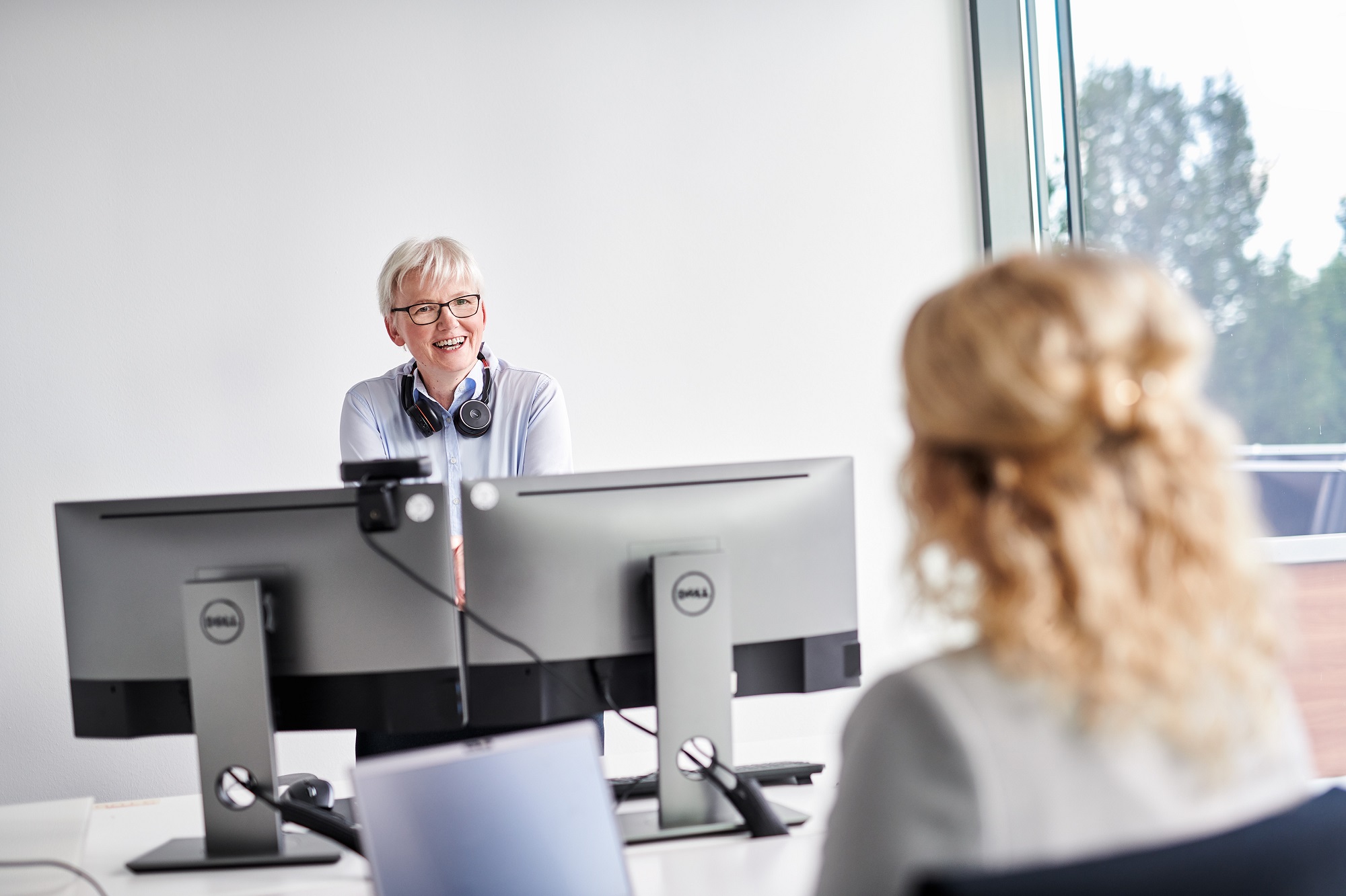 d.velop employees are talking in the office with a headset on