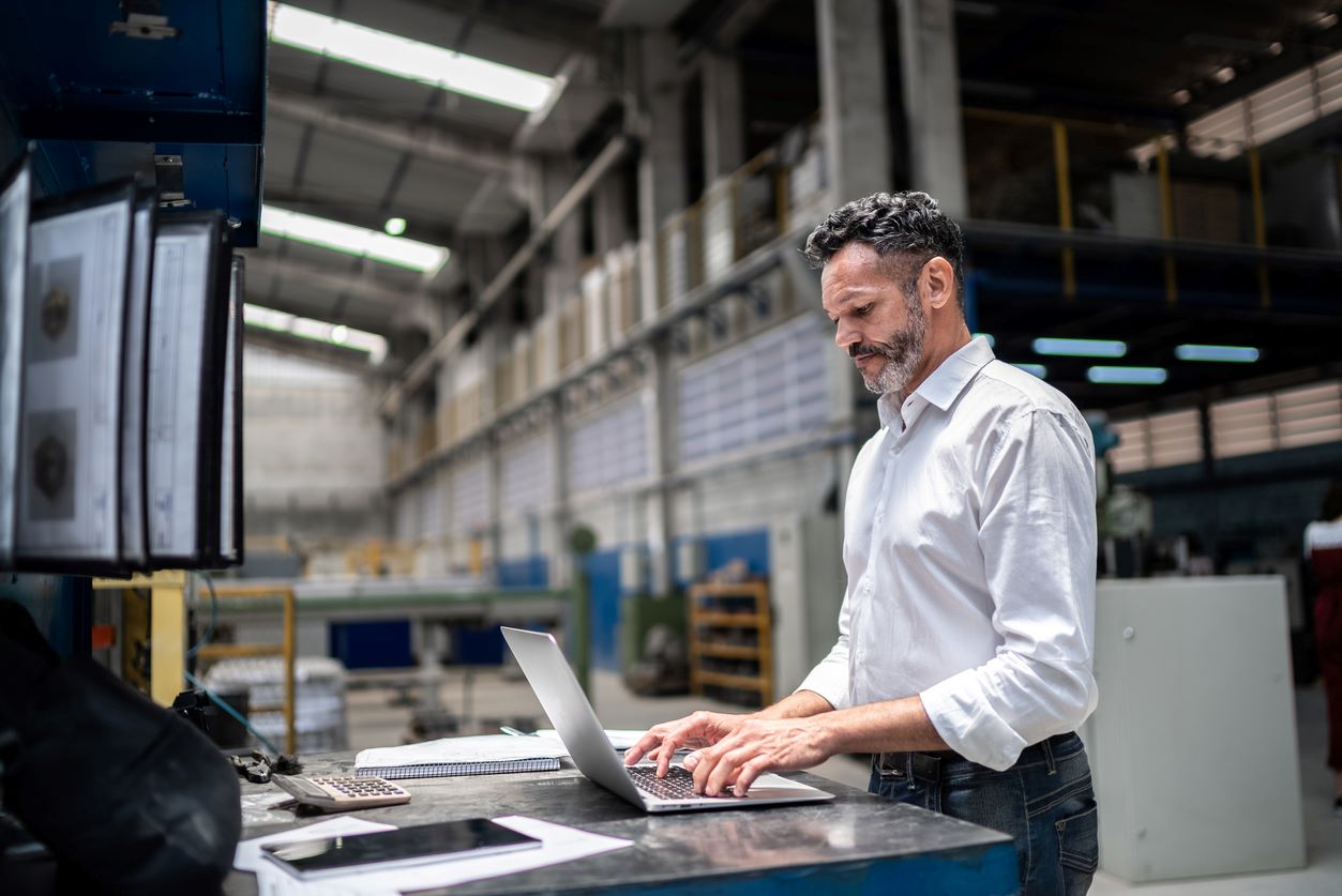 Man working on laptop in industrial building