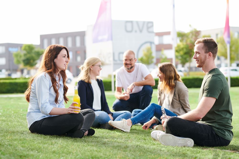 Group of people sitting together in the grass